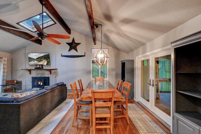 3207 Green Meadow Cir, Pocono Pines, PA 18350 - dining room featuring wood finished floors, a skylight, french doors, a brick fireplace, and a baseboard radiator