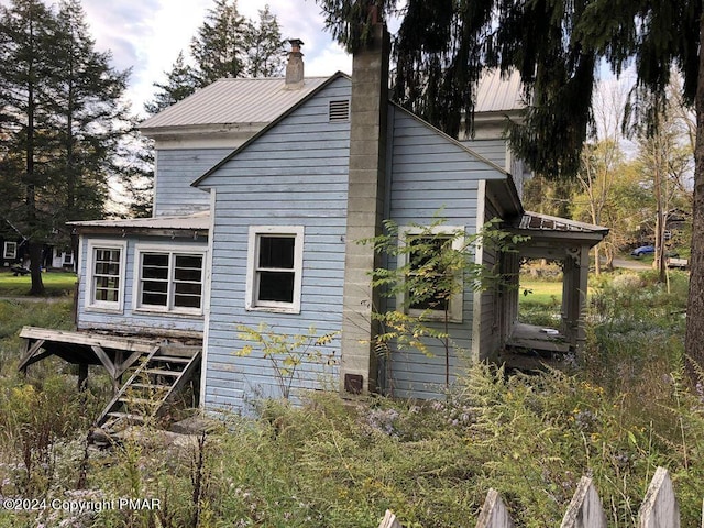 view of home's exterior featuring metal roof and a chimney