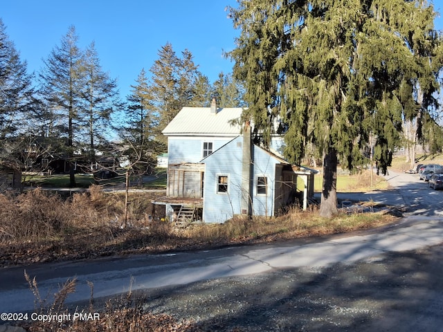 view of home's exterior with metal roof and a chimney