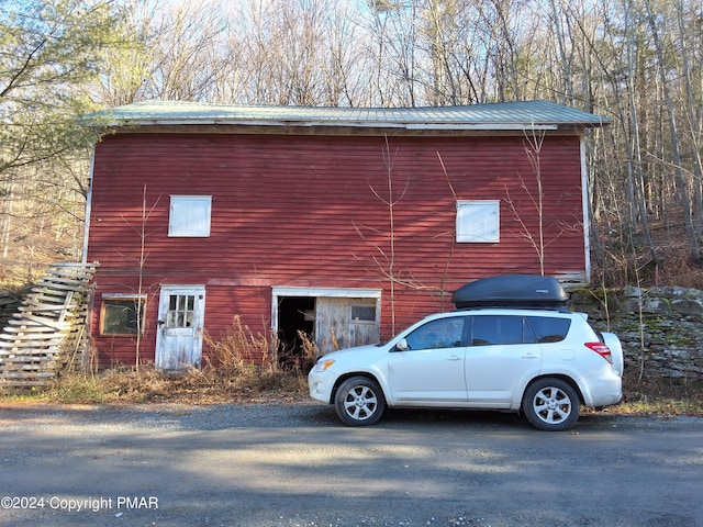 view of property exterior featuring an outbuilding and metal roof