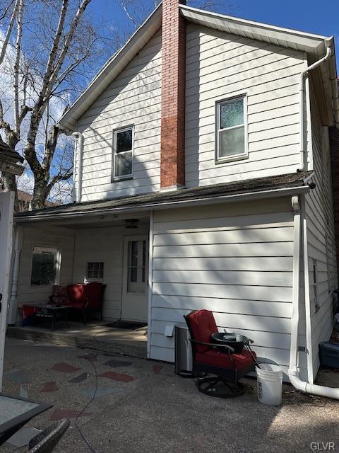 back of house with a patio area and a chimney