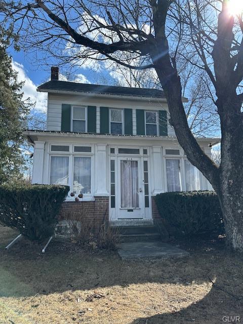 view of front of home with entry steps and a chimney