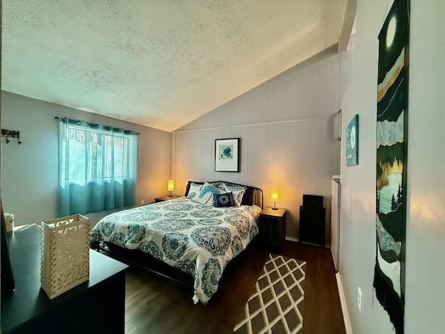 bedroom featuring baseboards, a textured ceiling, lofted ceiling, and wood finished floors