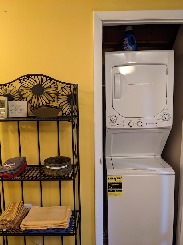 clothes washing area with stacked washer and dryer and laundry area