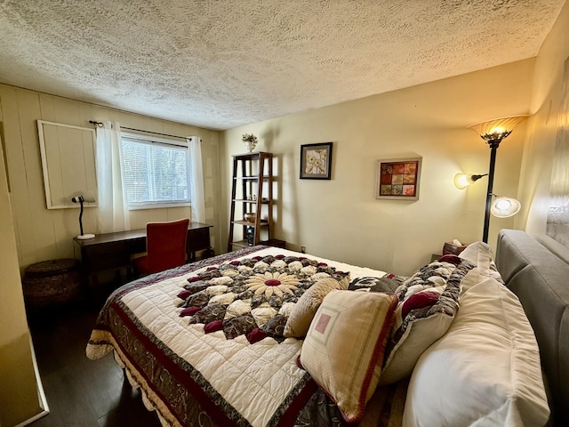 bedroom featuring wood finished floors and a textured ceiling