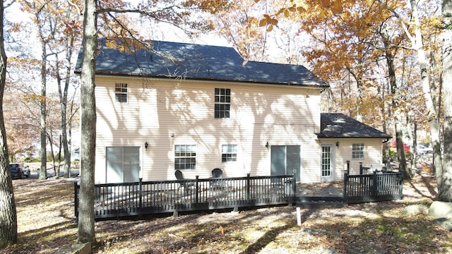 back of property featuring a wooden deck and roof with shingles