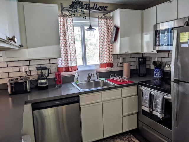 kitchen with white cabinets, a sink, stainless steel appliances, and tasteful backsplash