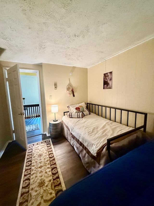 bedroom featuring wood finished floors and a textured ceiling