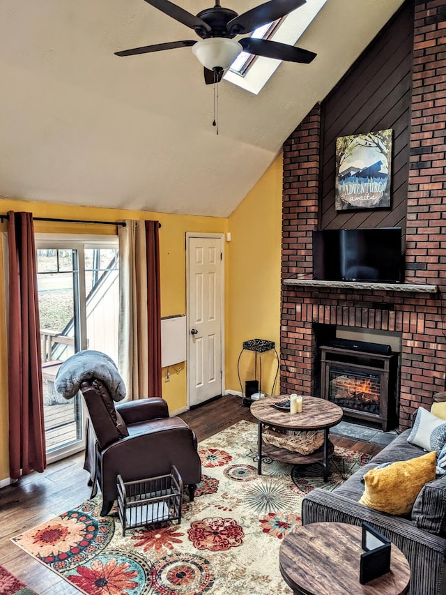 living room with lofted ceiling, baseboards, a ceiling fan, a fireplace, and wood finished floors