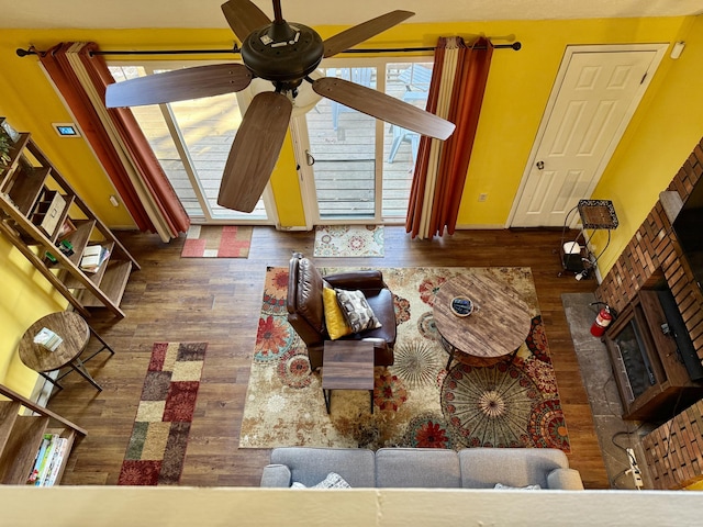 unfurnished living room featuring a fireplace, ceiling fan, and wood finished floors