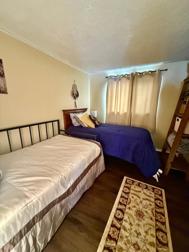 bedroom with a textured ceiling and wood finished floors