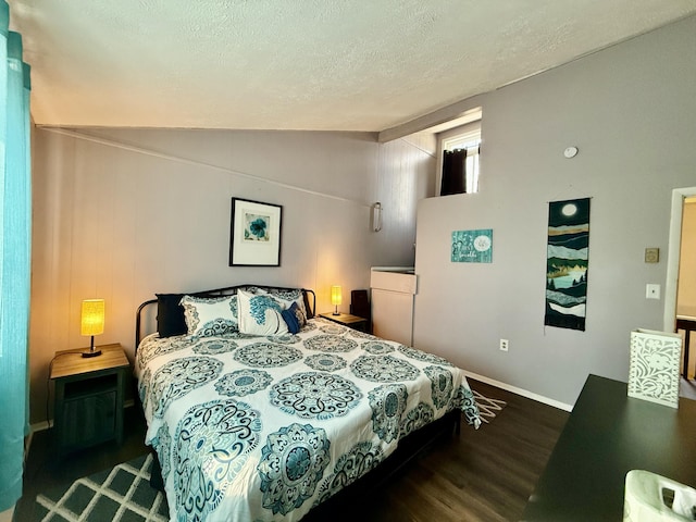 bedroom featuring baseboards, lofted ceiling, a textured ceiling, and wood finished floors