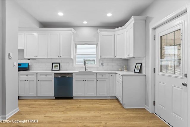 kitchen featuring a sink, light wood-style flooring, white cabinetry, and stainless steel dishwasher