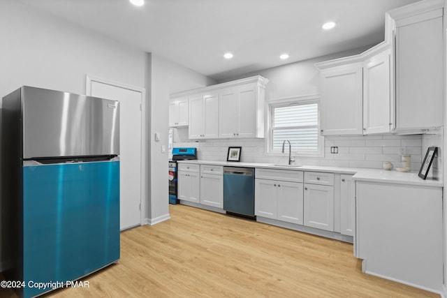 kitchen featuring stainless steel appliances, light wood-type flooring, a sink, and white cabinets