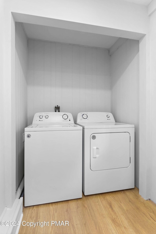 clothes washing area featuring light wood-type flooring, laundry area, and independent washer and dryer