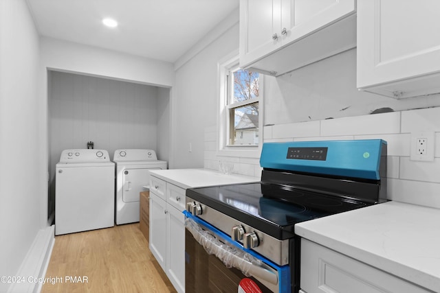 interior space with separate washer and dryer, light wood-style floors, white cabinets, stainless steel electric range, and decorative backsplash