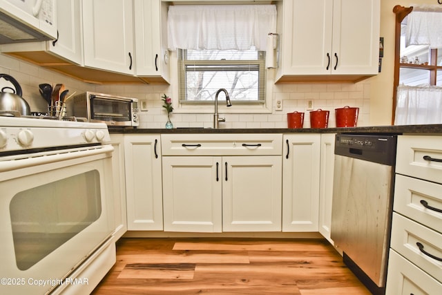 kitchen featuring white appliances, decorative backsplash, white cabinets, and light wood-style floors