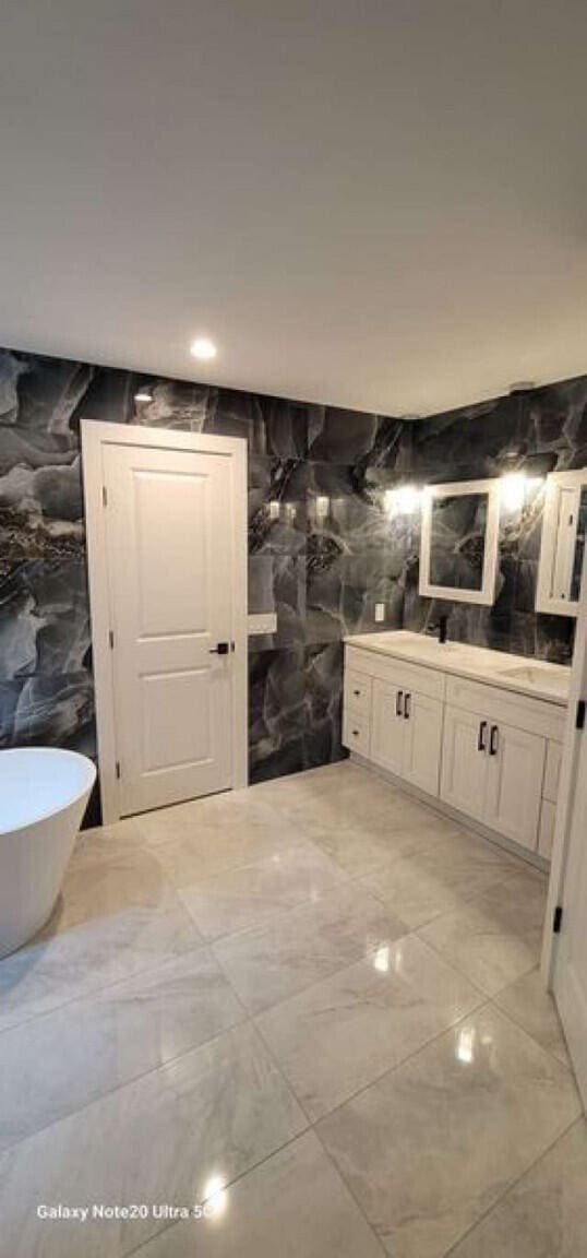 2210 White Oak Trl, Pocono Pines, PA 18350 - full bath with recessed lighting, tile walls, vanity, a freestanding bath, and marble finish floor