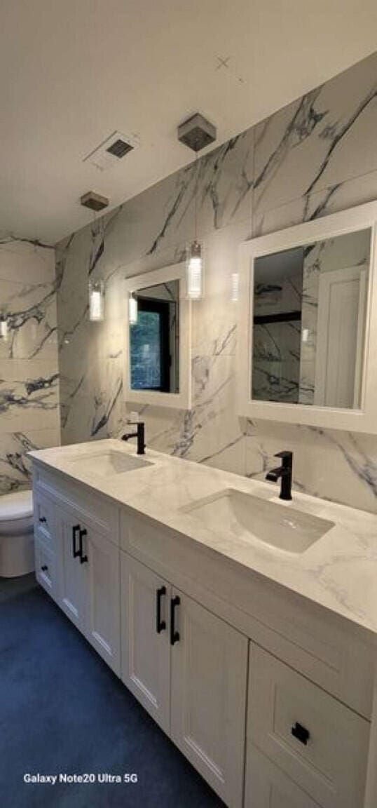 2210 White Oak Trl, Pocono Pines, PA 18350 - full bathroom with tile walls, toilet, double vanity, and a sink