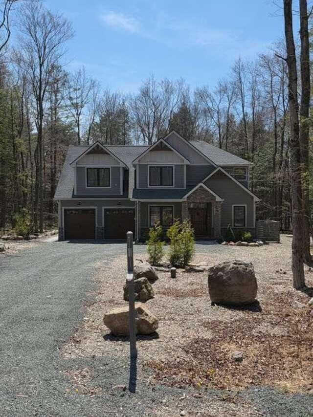 2210 White Oak Trl, Pocono Pines, PA 18350 - craftsman-style house with driveway, an attached garage, and roof with shingles