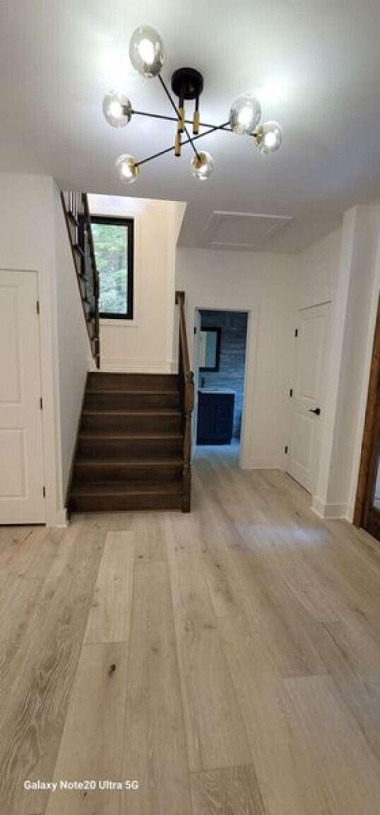 2210 White Oak Trl, Pocono Pines, PA 18350 - staircase featuring wood finished floors and a chandelier