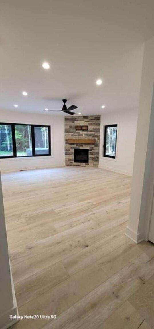 2210 White Oak Trl, Pocono Pines, PA 18350 - unfurnished living room featuring recessed lighting, ceiling fan, a stone fireplace, and light wood-style flooring