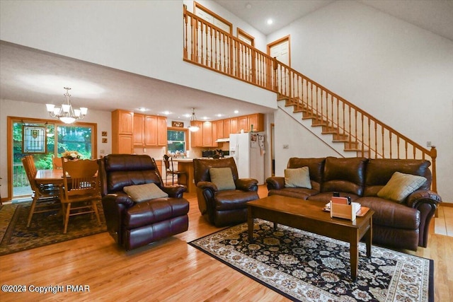 277 Packanack Dr, Clifton Township, PA 18424 - living area featuring light wood finished floors, a chandelier, stairs, a high ceiling, and recessed lighting