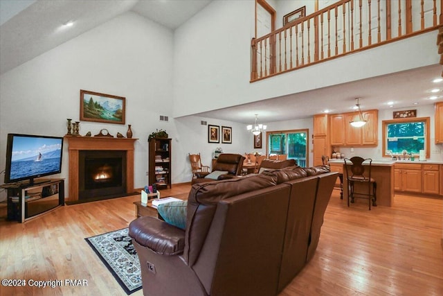 277 Packanack Dr, Clifton Township, PA 18424 - living room featuring light wood finished floors, a chandelier, high vaulted ceiling, a fireplace with flush hearth, and recessed lighting