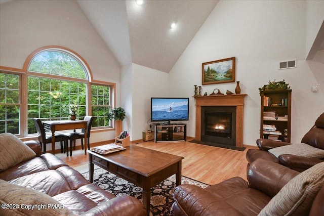 277 Packanack Dr, Clifton Township, PA 18424 - living area featuring high vaulted ceiling, a fireplace with flush hearth, and wood finished floors