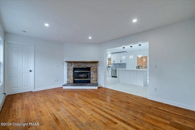 120 St Andrews Dr, Bushkill, PA 18324 - unfurnished living room with wood finished floors, baseboards, recessed lighting, and a fireplace