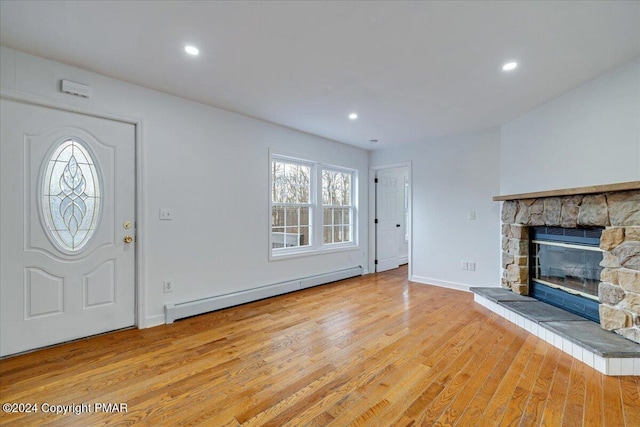 120 St Andrews Dr, Bushkill, PA 18324 - unfurnished living room featuring baseboard heating, wood finished floors, a stone fireplace, recessed lighting, and baseboards