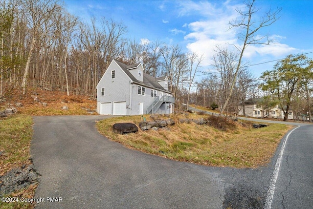 120 St Andrews Dr, Bushkill, PA 18324 - view of property exterior with a garage, stairway, and asphalt driveway