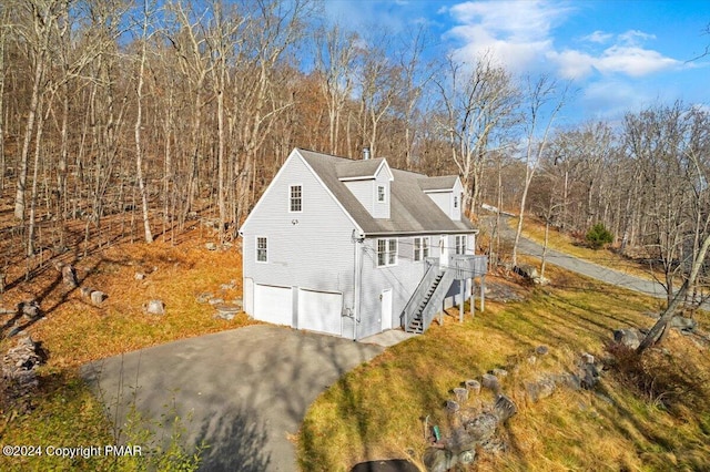 120 St Andrews Dr, Bushkill, PA 18324 - view of side of home featuring driveway, stairway, an attached garage, a chimney, and a wooden deck