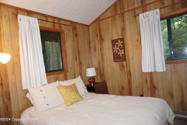 bedroom featuring lofted ceiling and wooden walls