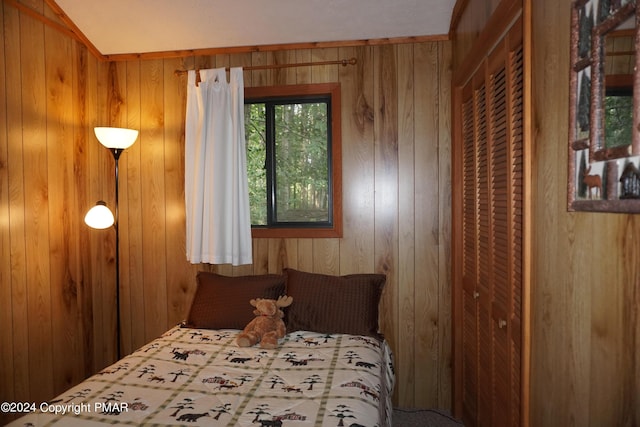 bedroom featuring wooden walls and a closet