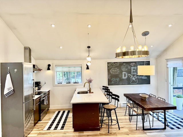 1110 Lehigh Cir, Tobyhanna, PA 18466 - kitchen with stainless steel appliances, vaulted ceiling, light wood finished floors, wall chimney range hood, and light countertops