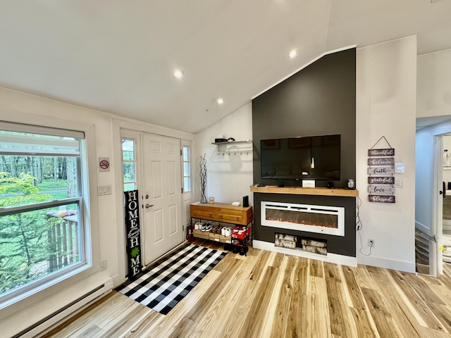 1110 Lehigh Cir, Tobyhanna, PA 18466 - foyer entrance featuring baseboard heating, wood finished floors, vaulted ceiling, a glass covered fireplace, and recessed lighting