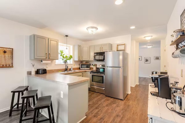3114 Fairfax Ter, East Stroudsburg, PA 18301 - kitchen featuring a sink, light countertops, a peninsula, wood finished floors, and stainless steel appliances