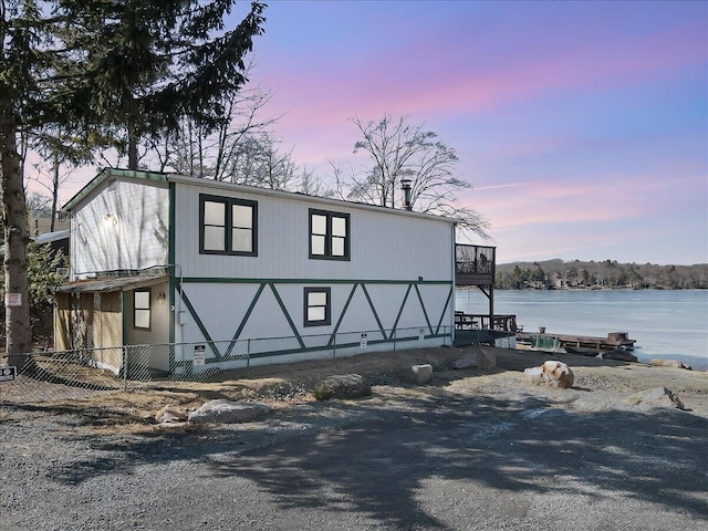 view of front facade featuring fence and a water view