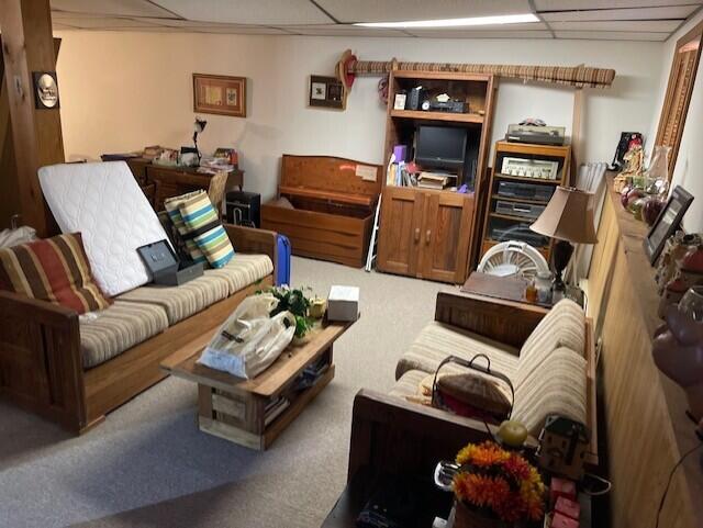 carpeted living room with a paneled ceiling