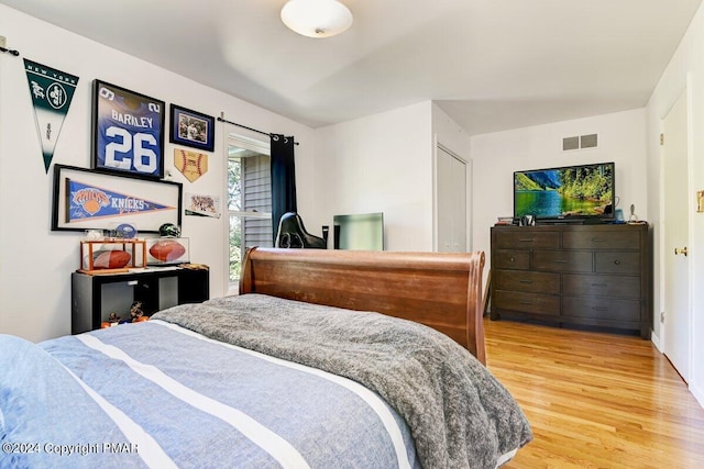 bedroom with light wood-type flooring and visible vents