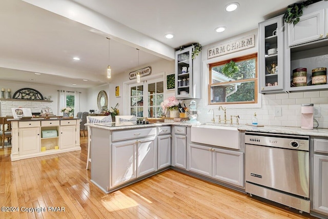 kitchen with a peninsula, a sink, stainless steel dishwasher, light wood-type flooring, and open shelves