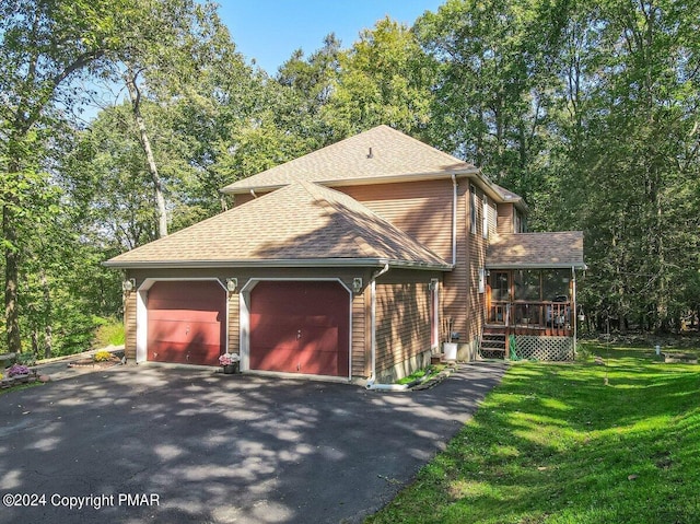 view of side of property with a garage, a yard, driveway, and a shingled roof