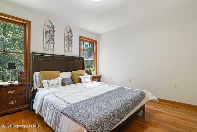 bedroom with baseboards and wood finished floors