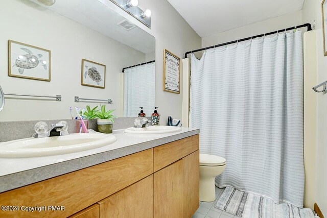 full bath featuring toilet, double vanity, visible vents, and a sink