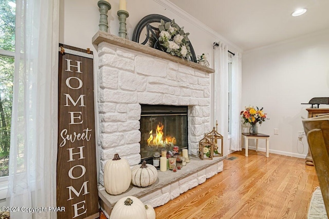 details with a fireplace, visible vents, ornamental molding, wood finished floors, and baseboards