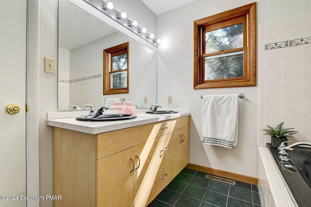 full bath featuring plenty of natural light, a sink, visible vents, and tile patterned floors