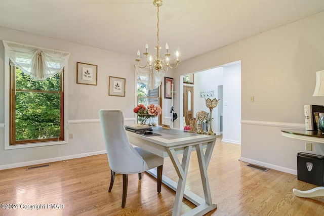 dining area featuring a chandelier, baseboards, visible vents, and light wood finished floors