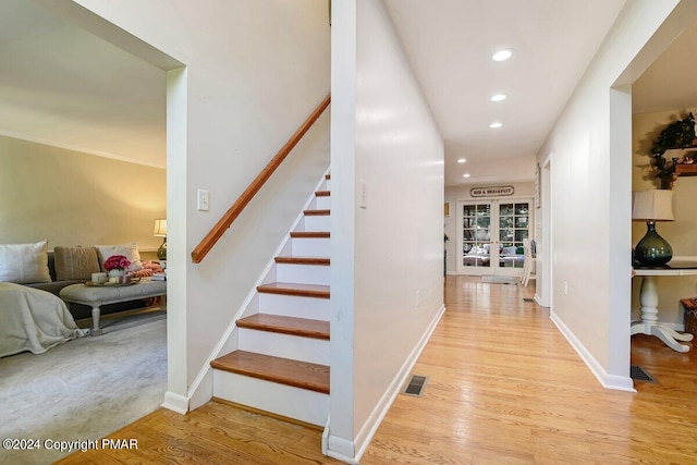 stairs featuring visible vents, baseboards, and wood finished floors