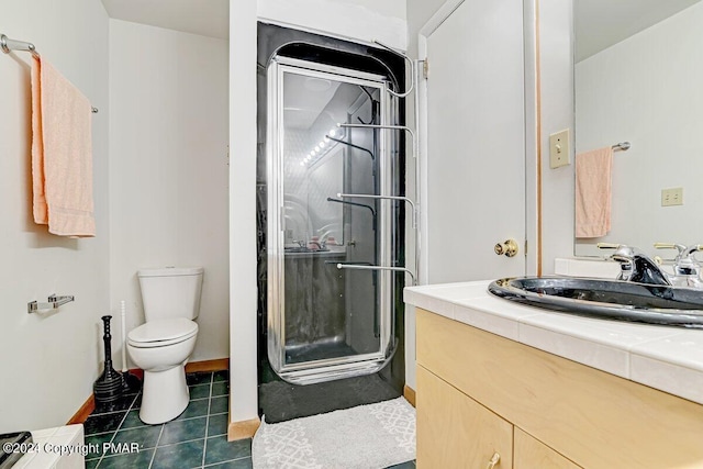 full bath featuring toilet, a shower stall, vanity, and tile patterned floors